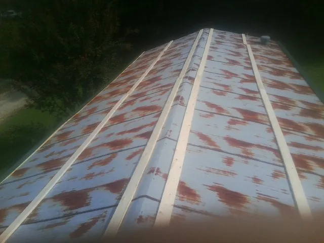 Rusted metal roof panels with new wood purlins before replacement — Storm Damage Roof Repair in Six Mile by Roofing Brothers