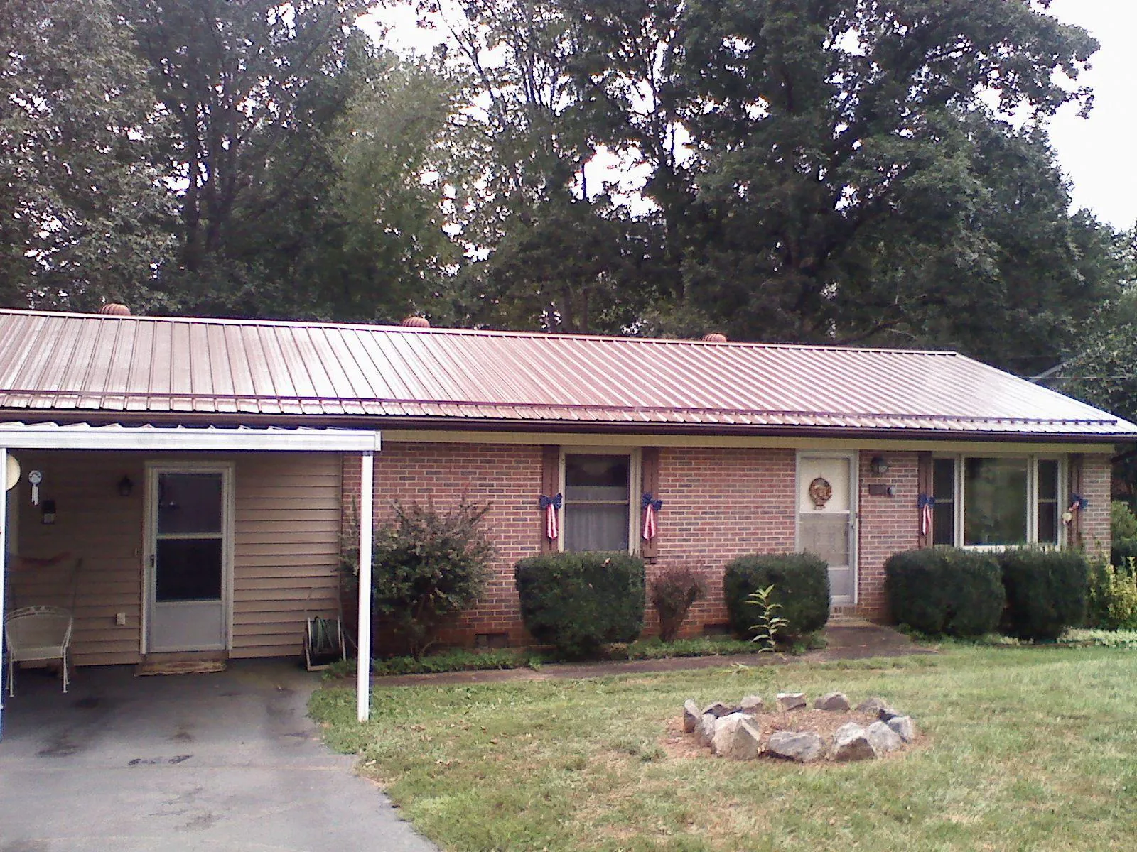 Bronze metal roof and carport on a brick ranch home — Roof Repair work by our crew in Six Mile