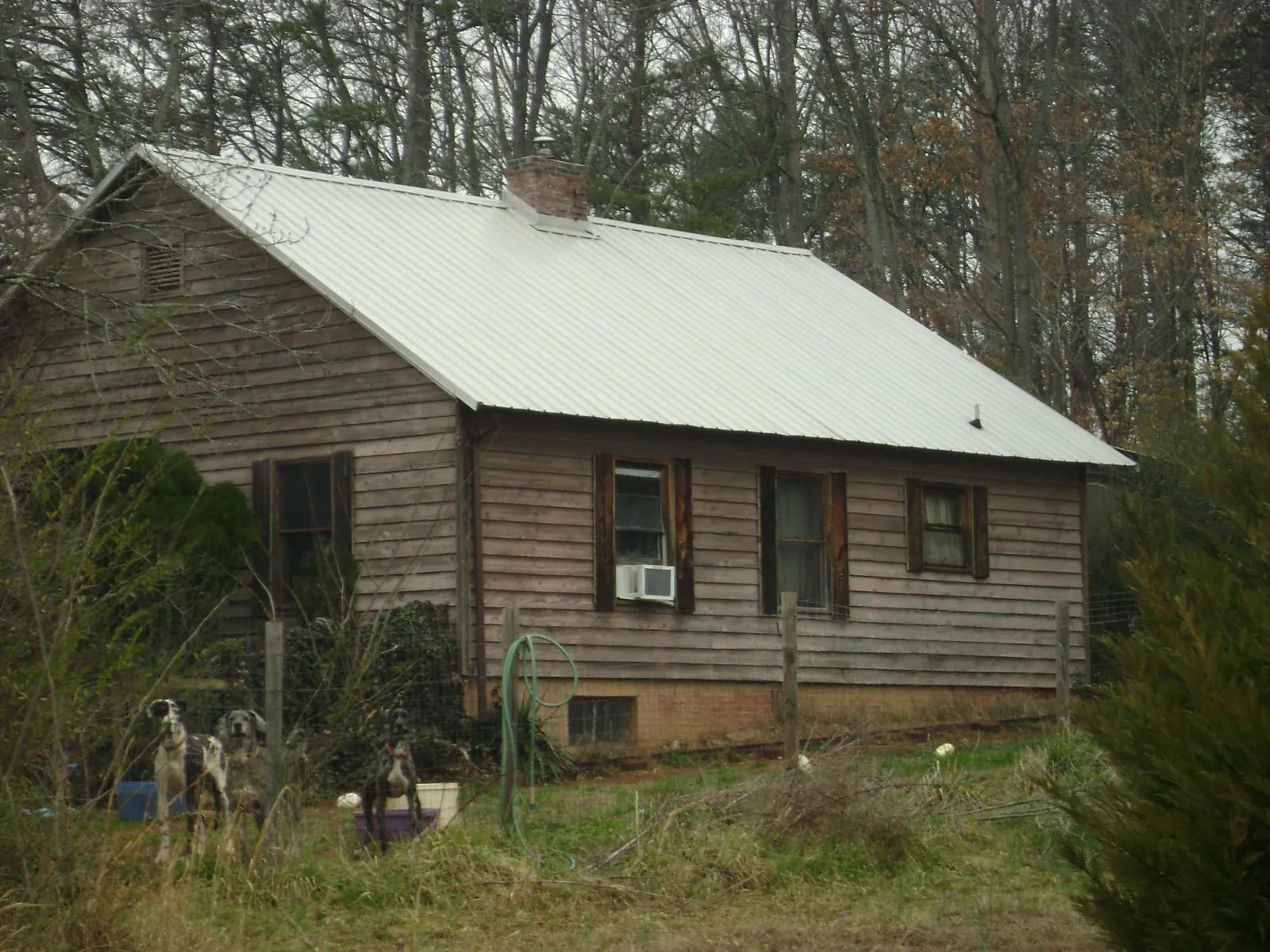 White metal roof on an old wood sided farmhouse, from a Metal Roof Installation job in Six Mile